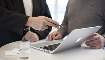 A financial adviser explaining a Financial Services Guide to a client in a professional setting