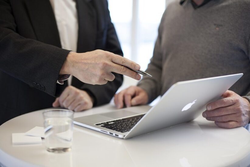 A financial adviser explaining a Financial Services Guide to a client in a professional setting